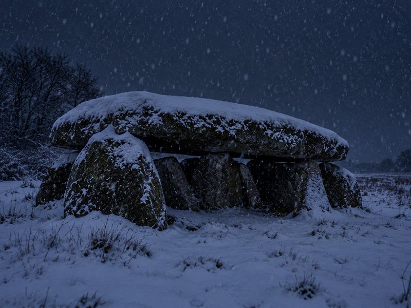 Sneeuwstorm boven een hunebed