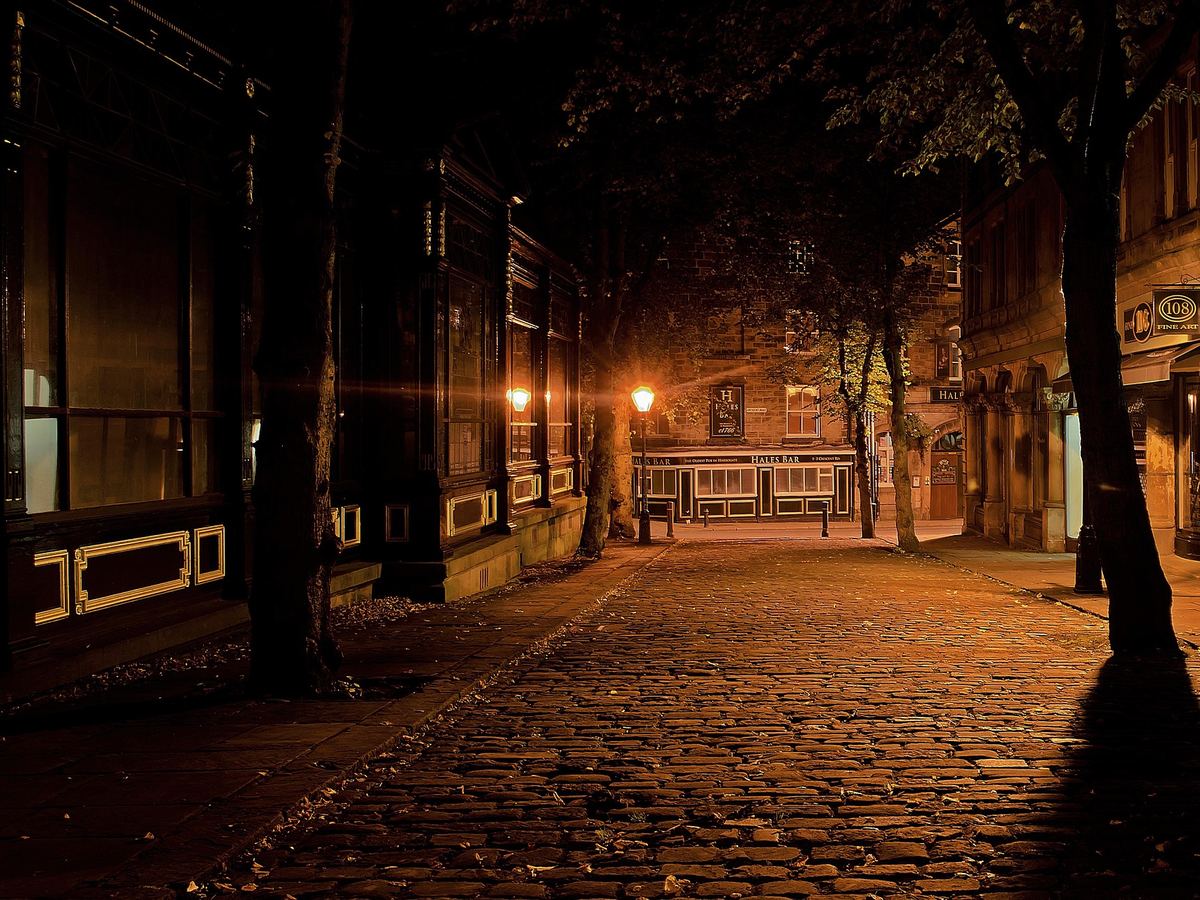 Verlaten steeg bij nacht met een brandende lantaarn